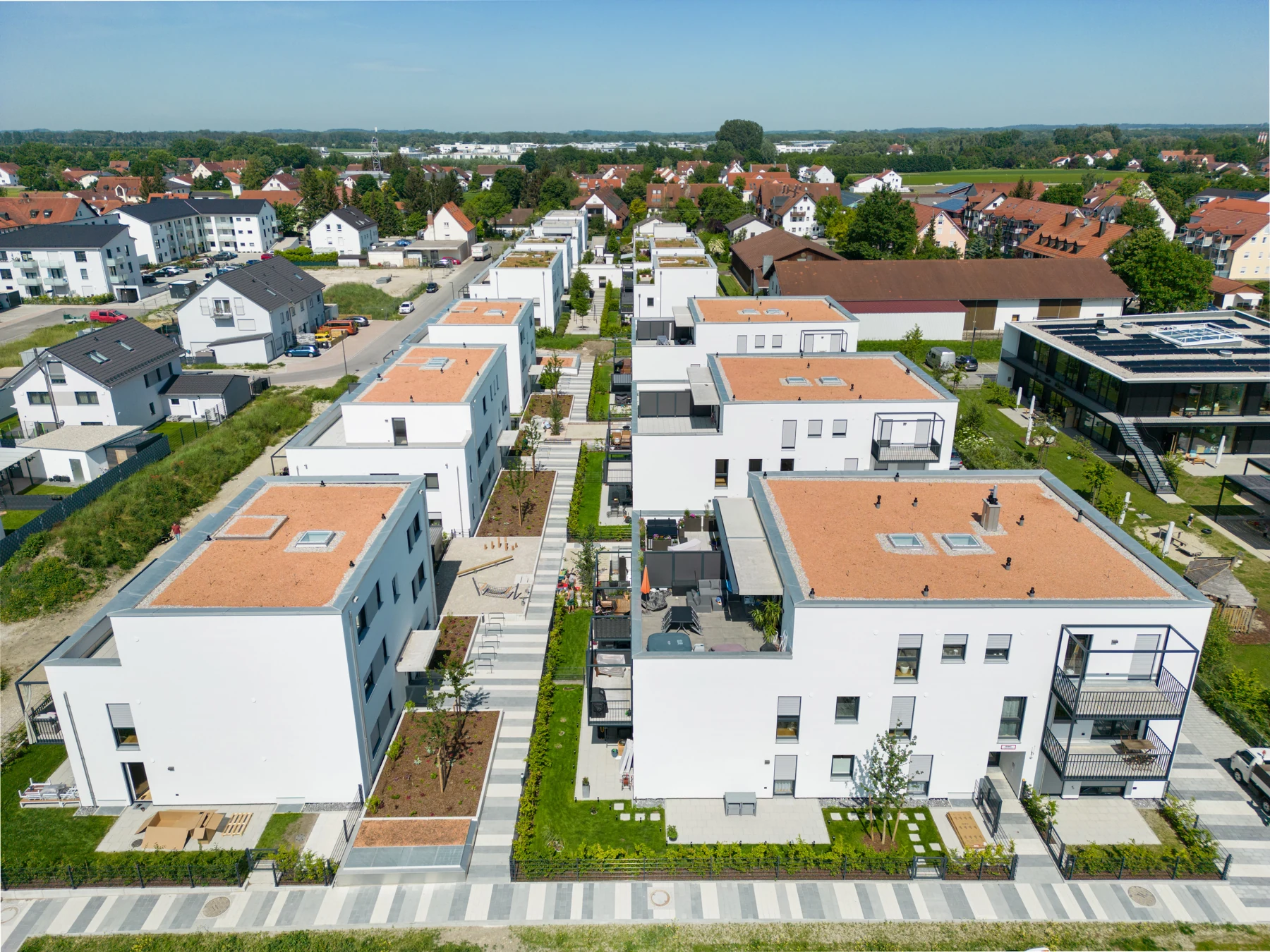 Moderne Wohnanlage mit klarer Architektur, Balkonen und begrünten Außenbereichen